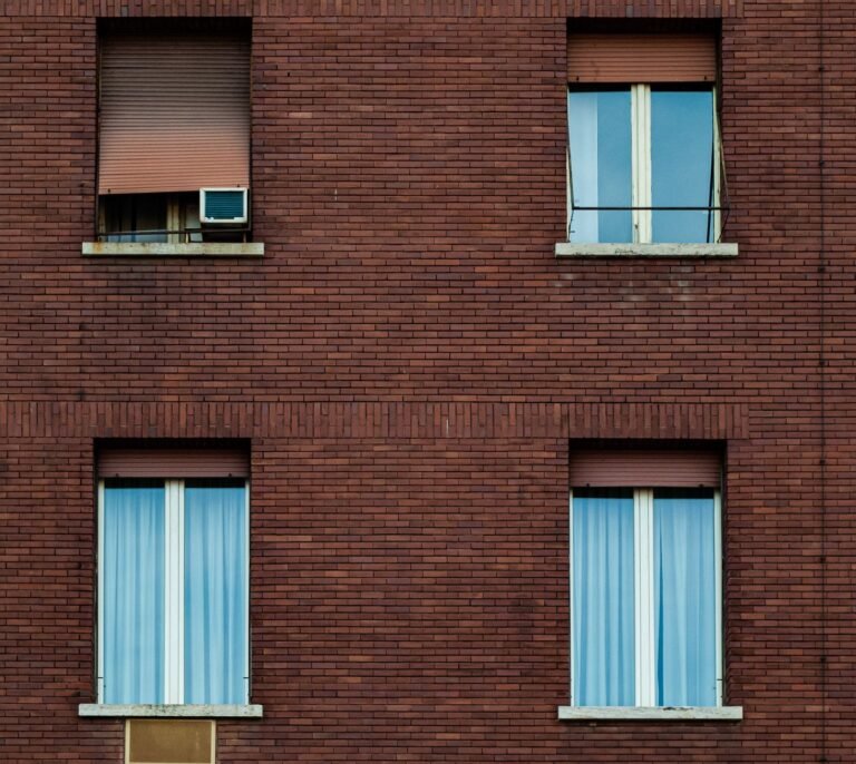 Rollladen elektrisch nachrüsten – Klinkerfassade mit teilweise heruntergelassenen Rollläden