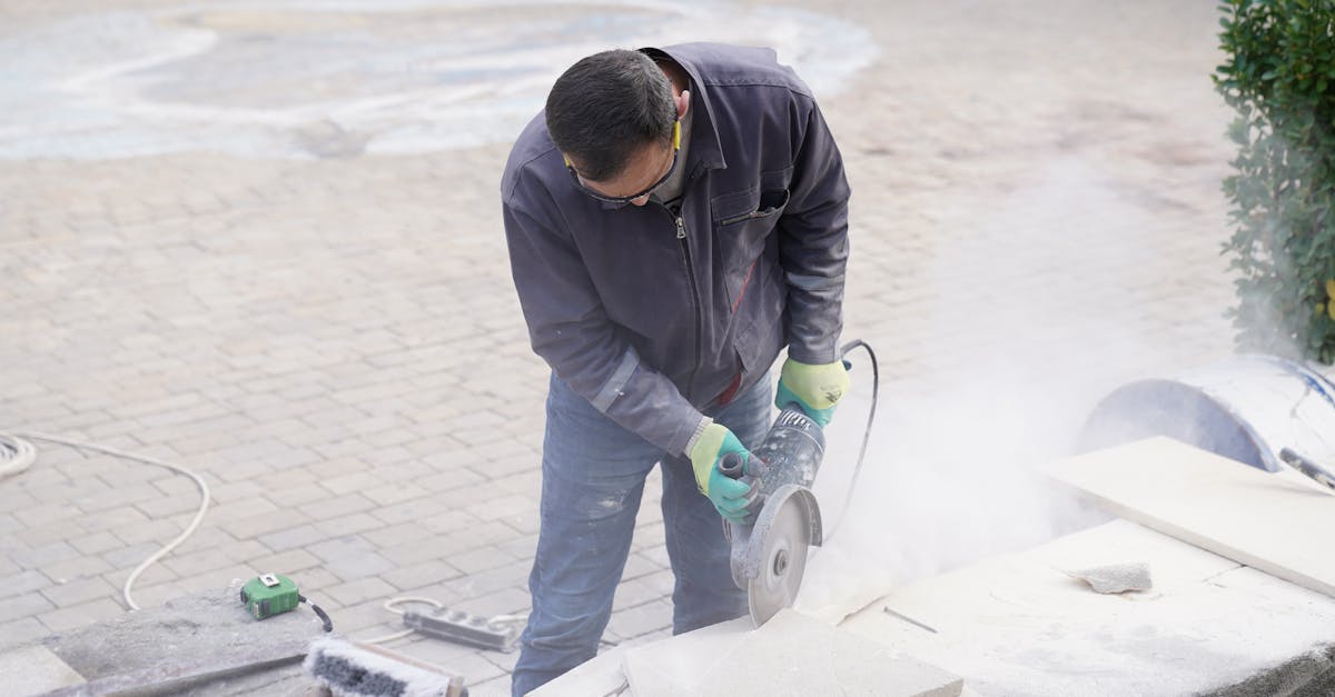 Sandstein sägen Anleitung – Arbeiter schneidet Steinplatten mit Kreissäge