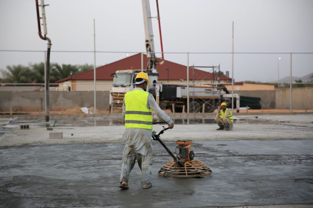 Beton abschleifen 1 cm – Arbeiter mit Schutzhelm und Maschine auf einer Betonfläche