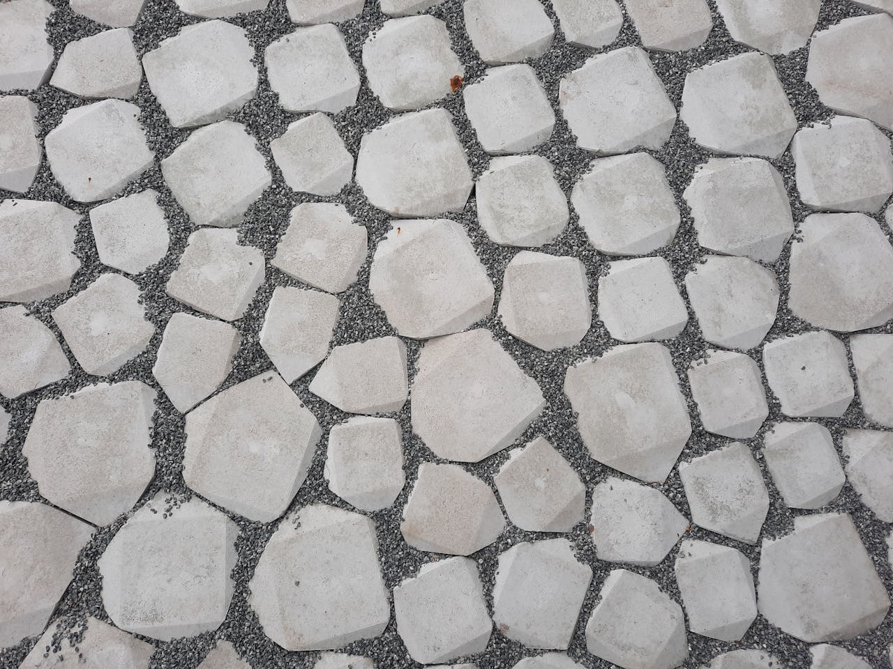 Betonplatten streichen – geometrischer Steinweg mit weißen Kieseln