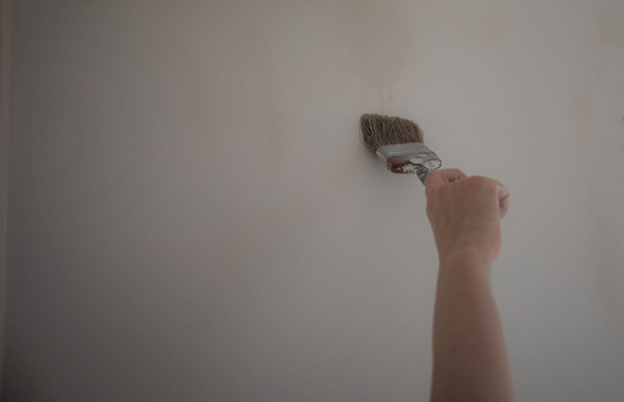 Marmor-Fensterbank streichen – Hand mit Pinsel beim Streichen