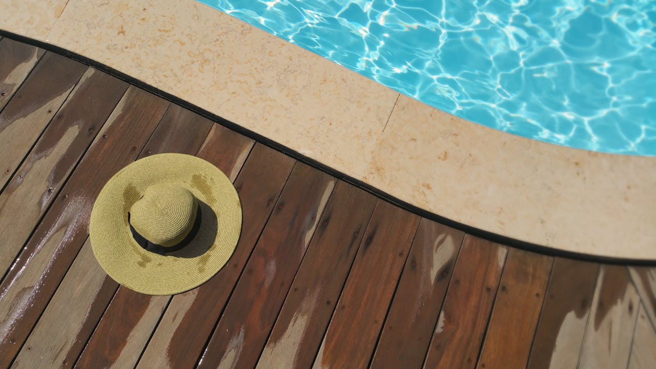 Pool-Podest selber bauen – Strohhut auf Holzdeck am Pool