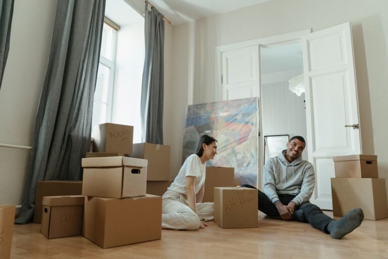 Stressfreier Umzug beim Immobilienwechsel – Paar zwischen Umzugskartons in der neuen Wohnung