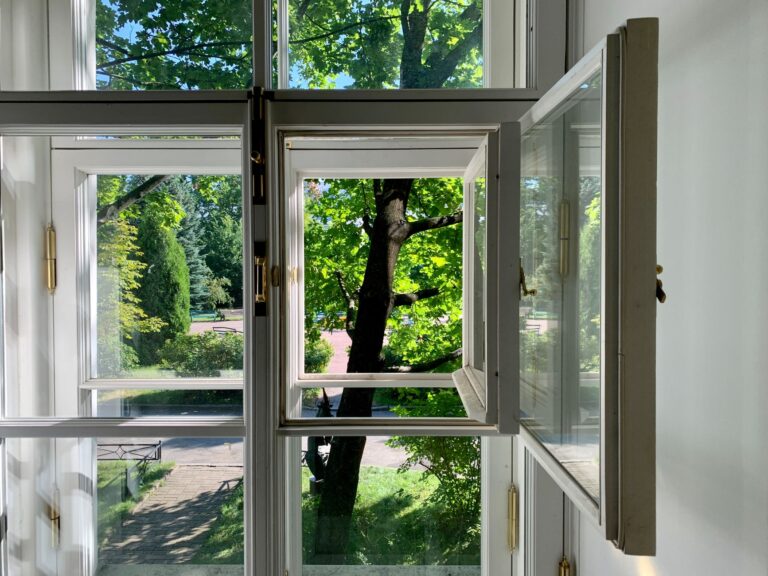 Schimmel vorbeugen durch Lüften – offenes Fenster mit Blick ins Grüne
