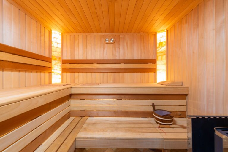 Sauna Stromverbrauch – Innenraum einer Saunakabine mit mehrstufigen Holzbänken